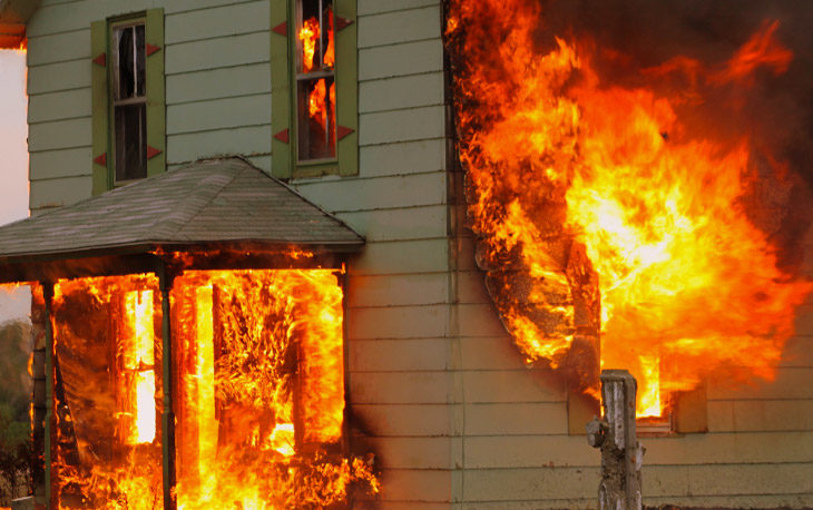 Home on fire with balls of flames bursting out the windows
